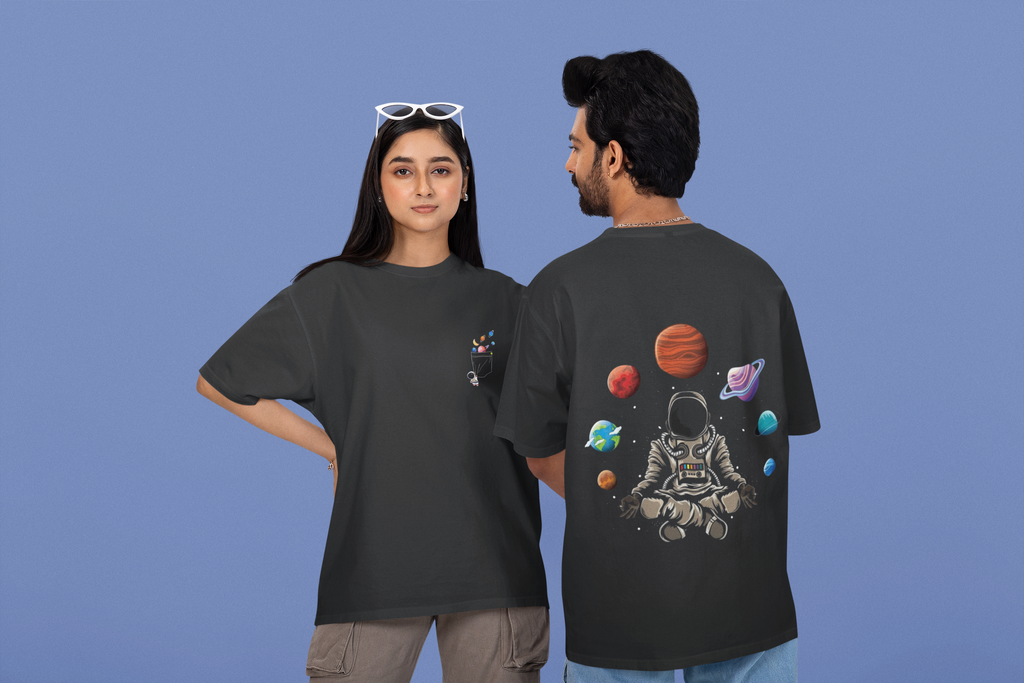 Two people wearing black t-shirts with space-themed designs on a blue background