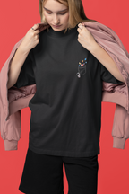 Person wearing a black t-shirt with a pocket design against a red background